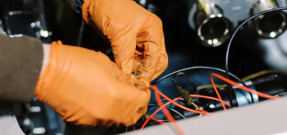Two hands wearing gloves holding electrical wiring